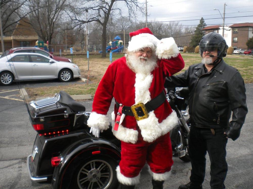Santa straightens his hat after the ride on ER Pat Monks Harley