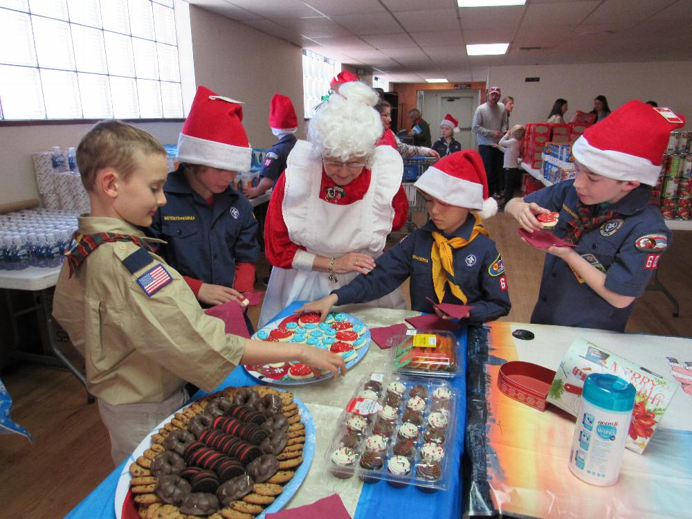 Mrs Claus ( JR Latimer) and the Scouts in the cookie area of the "Kids Corner" of the Christmas Basket area. The Scouts helped with the basket distributions