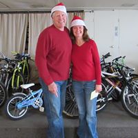 Christmas Basket Elves Kurt & LaRae helping with selection of bikes and sign up for kids to get helmets
