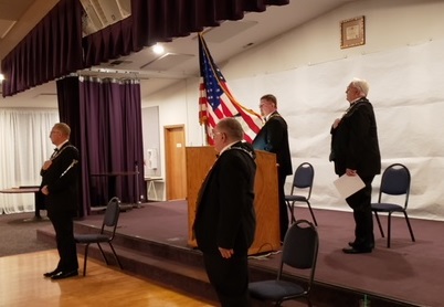 Lodge Esquire Rob Dahl (L), Chaplain Dave Ward(C) and Secretary John Fowler (R) salute the flags, as Exalted Ruler Dave Southwick speaks of the beauty of the American flag