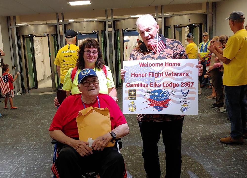 Trustee Stan Chesneski displays a Welcome Home sign during the 2019 Honor Flight return. The Lodge donated $1,500 provided by an ENF Gratitude Grant.