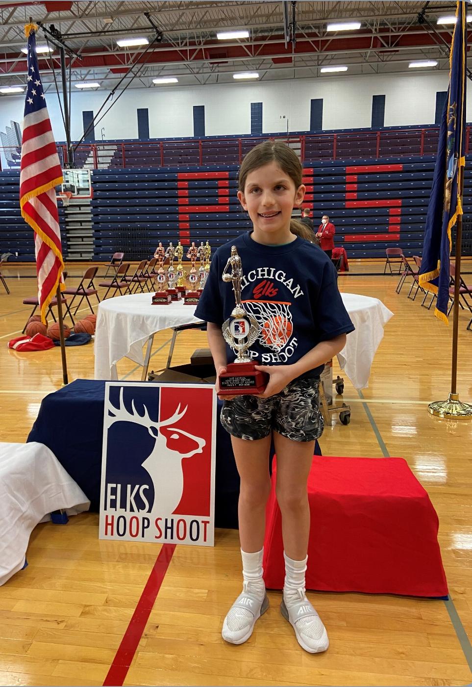 Harper Malloy accepting her 8/9 year-old 2nd place Elks Hoop Shoot State Finals trophy.