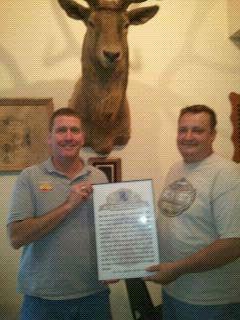 Iola E.R. Kyle King presenting Chanute E.R. Terry Row with a copy of the 11 O'clock Toast recognizing Chanute's Lodge support to Iola's in many joint activities in the past year.