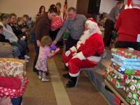 Santa and his helpers give gifts to all the children and their siblings.