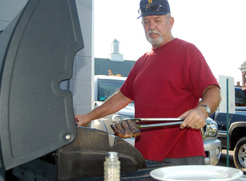 Member Chuck Billings cooking steaks for a dinner to raise funds for Bath's Veteran's Committee.