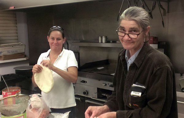 PEY Jessie Sutfin (R) and volunteer chef Dawn Burton (L) in the kitchen making pies for another Pizza Night in the lounge.