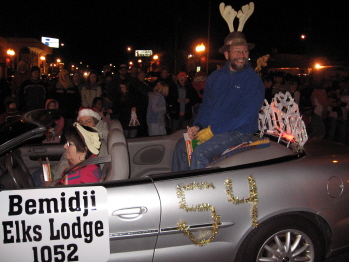 P.E.R Dr. Mark Christensen joins Candace and David West during the 2006 Night We Light parade down Beltrami Ave. Passing out candy canes and child ID card invites were Elk girls Dre Hendrickson and Holiday Hedeen. Hot apple cider and peppermint patties were served with bars and cookies up in the lodge while Lisa Habermann conducted the Child ID cards.