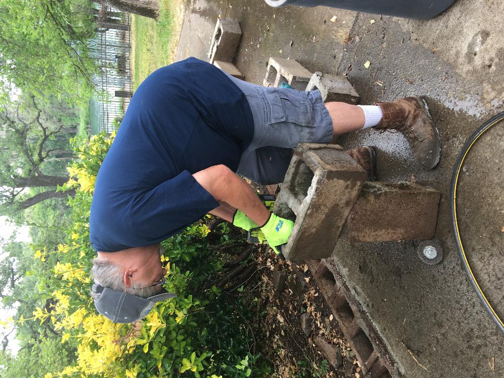 Elky-Doer Pat Stone repairing the block wall on the path to the river trail. 