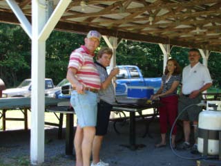 Exalted Ruler Pete Byron, wife Georgia, Est. Leading Knight Dave Holmes, and wife Marilyn overseeing the grilling at the annual Elks mixed picnic