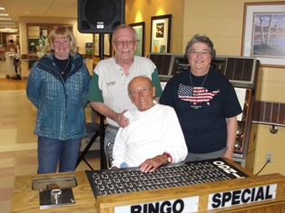 The Rochester, NH Elks Lodge #1393 and Rochester Emblem Club #40 send representatives to coordinate a scheduled bingo night twice a year for the residents of the NH Veterans Home, located in Tilton, NH. 

For more than a century, the New Hampshire Veterans Facility has been a home and a health resource for granite state armed forces veterans. Established in 1890 as the Soldier's Home for Civil War Veterans, it has provided care and comfort for thousands who have served our country and fellow citizens.Located in the heart of the Lakes Region and the foothills of the magnificent White Mountains, the scenic beauty surrounding the Home - combined with the warm fellowship shared by residents, staff, and volunteers - creates a unique environment for those who have made personal sacrifices in the military and now need assistance to care for themselves.
 
The mission of the New Hampshire Veterans Home is to provide high quality, professional, long-term care services to the granite state's elderly and disabled veterans with compassion, respect, and dignity. The Rochester, NH Elks Lodge 1393 and Emblem Club #40 are dedicated to the support of this mission and representatives attend and coordinate two bingo nights, support a Christmas party and a summer cookout. Other Elks Lodges and auxiliaries also support this effort with separate bingo nights scheduled by our State Chairman, Jim Stewart, who works with the staff at the Home to coordinate various activities and initiatives.
 
Picture Caption: Back Row, l to r, Linda Gaskell, Past President, Rochester Emblem Club #40; David Keller,PER,PDD (Rochester Elks) and Arlene Fall, Past President, Rochester Emblem Club #40.
 
Front row center: Calling numbers for the evening bingo games and doing an outstanding job with this assignment was resident Andy Pare, age 90!
