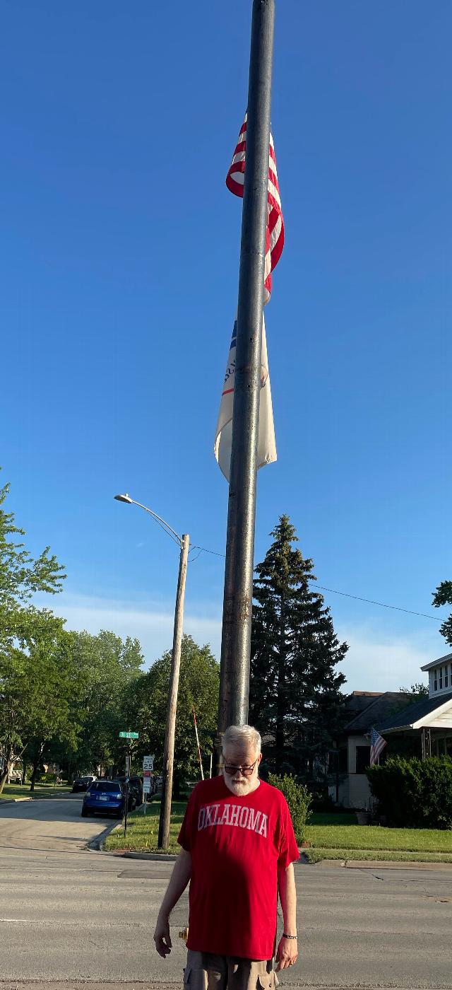 Mark Roegner standing below the flag he donated to the lodge!