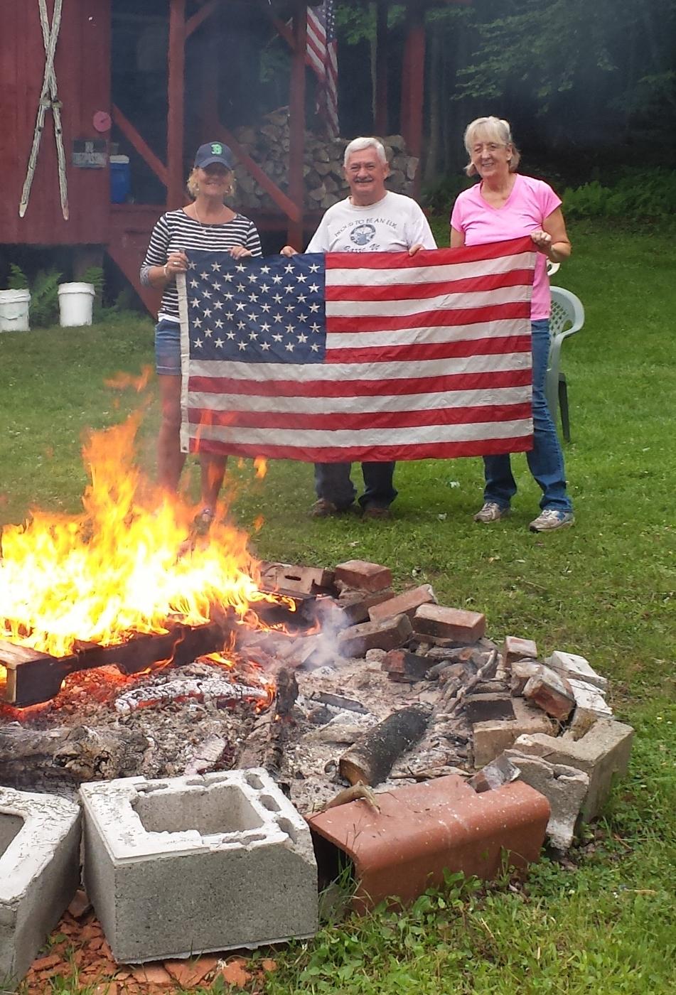 Over 250 worn, tattered flags were properly retired.  Pictured are Maureen Lawson and Chip and Terry Paine