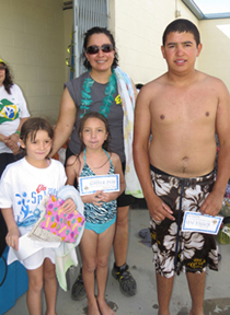 Winners of summer swimming passes were Hailey Barker, Layla Gonzalez and Joel Mendoza. They are pictured with Youth Activities Chairman Maria Sanchez.
