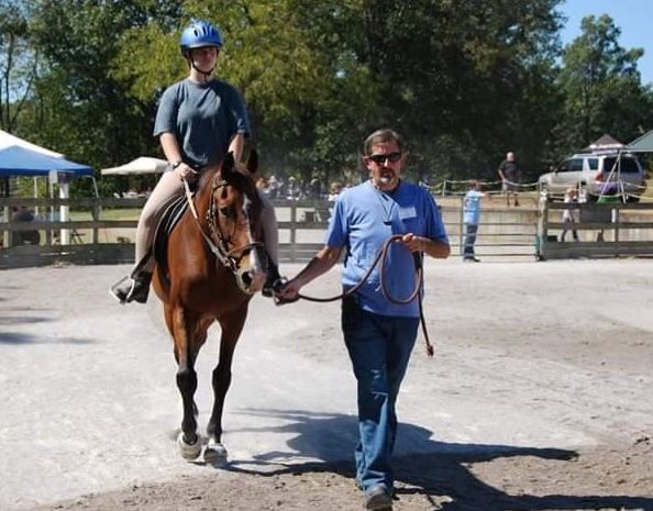 ER Bryan Brewer leads a horse and rider around the ring at the 2019 Leg Up Student Horse Show on Sept. 21.