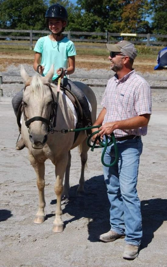 Elk Phillip Trimble gets acquainted with a young rider before leading her horse around the ring at the 2019 Leg Up Student Horse Show.