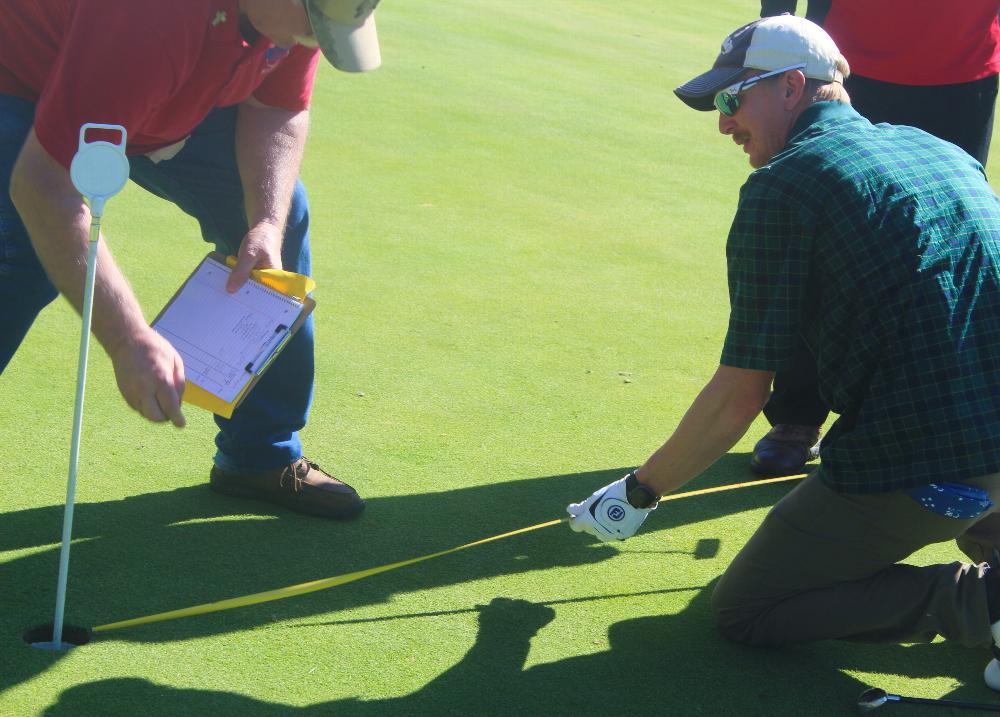 Scholarship Committee Chairman Walter Kauhn records measurement for "Closest to the Hole"