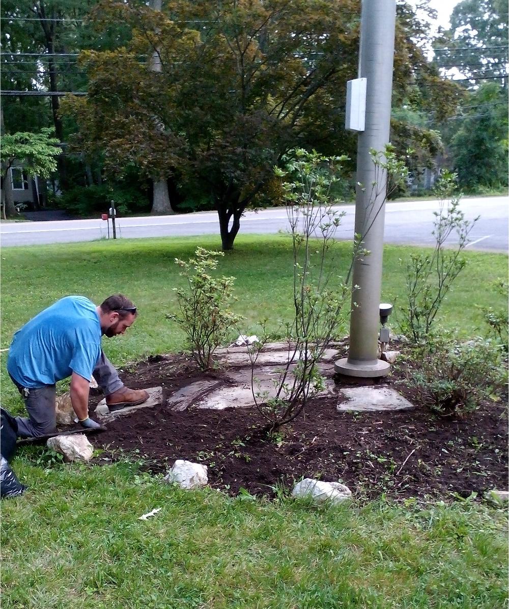 Liam O'Donnel placing flagstones around our Lodge flagpole in preparation for Flag Day 2018.