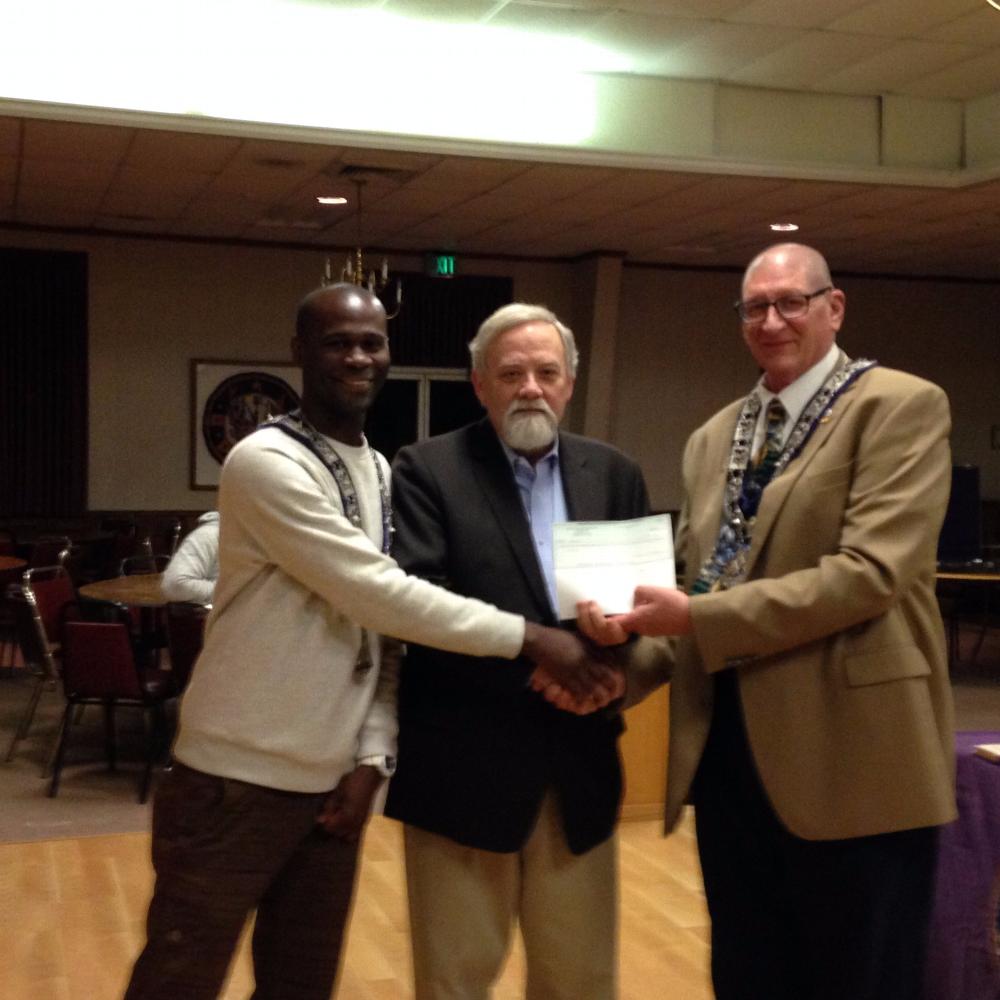 Carl Robinson accepts a check for the Welcome Home Program from Wilford Davis and Stephen Williams.  The Grant monies are to purchase household goods for a homeless veteran.