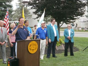 Phil Barrett addresses public at July 4th Opening Ceremonies as ER Tom Nealon and Lou Stoller PER look on