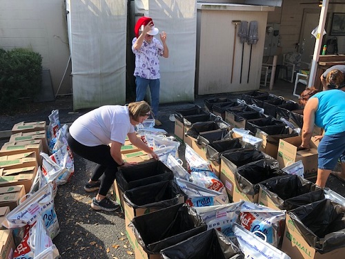 Volunteers outside working on refrigerated food items for Bootstrap Christmas.