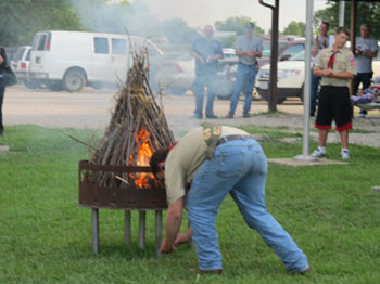 Boy Scouts preparing the fire traditionally with flints and dried grass
