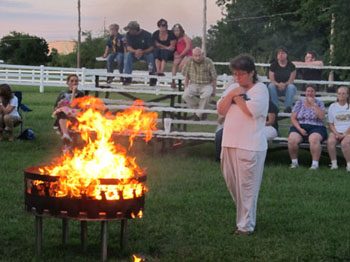 Brownie Leader Kathy Henderson in a moment of reverence prior to depositing her flag into the cauldron.