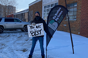 Elk volunteer holds up a sign reading 'You Are The Best.'