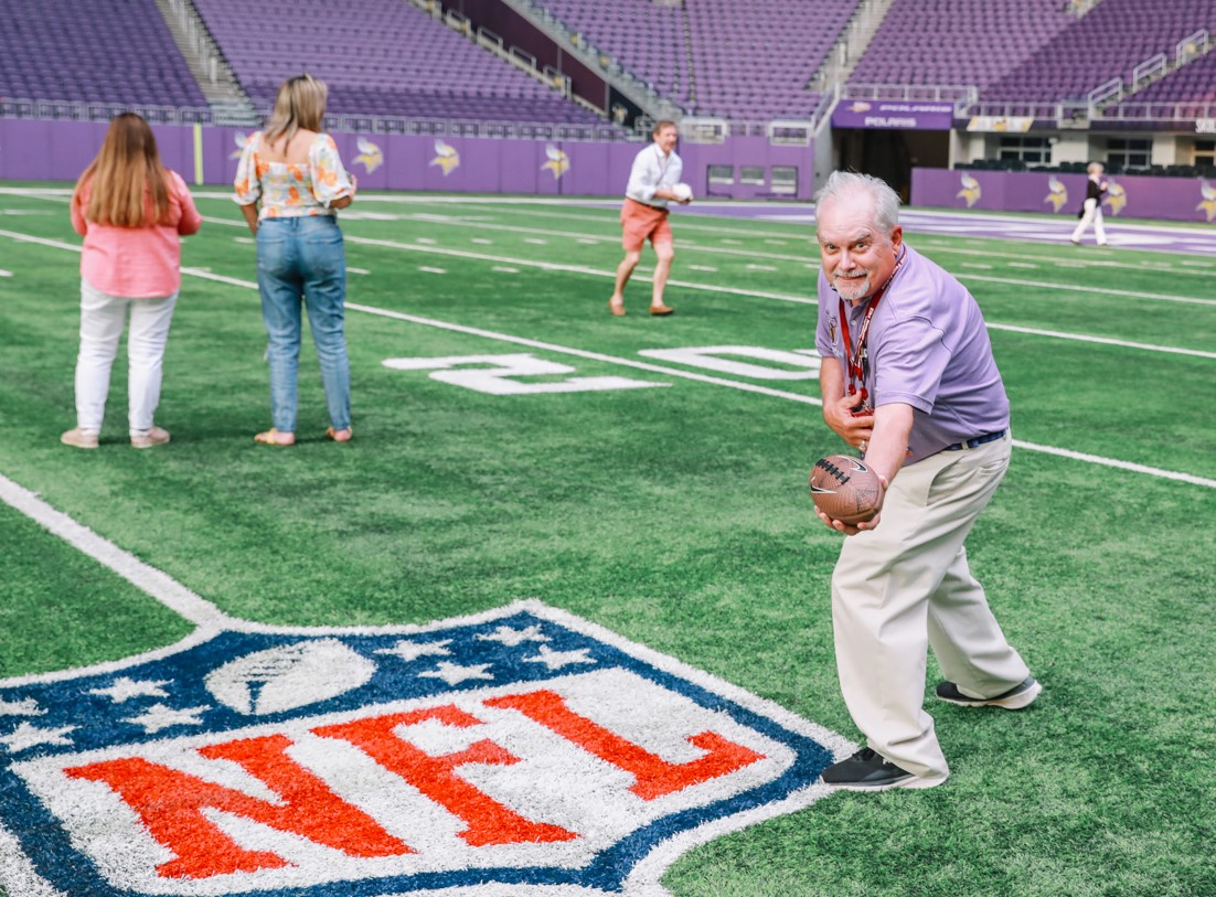 An ENF donor catches a football at the Vikings Stadium.