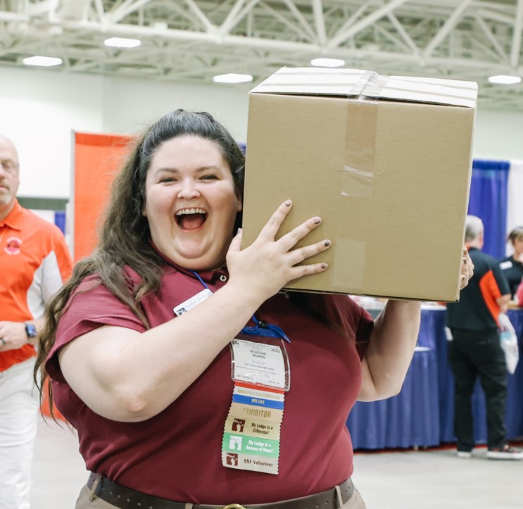 An ENF staff member carries a box of books for the ENF's supply drive.