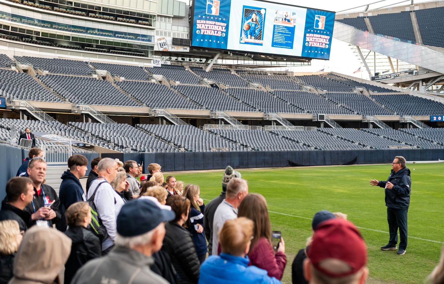 Hoop Shoot attendees take a guided tour of Soldier Field while Finalist trading cards play on the jumbotron.