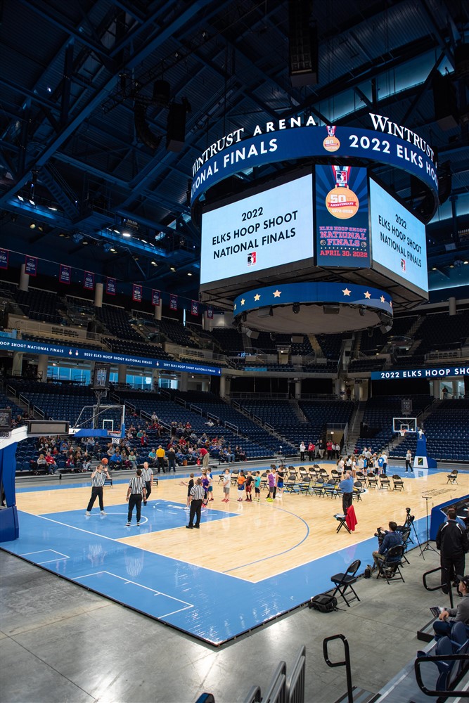 The 2022 Hoop Shoot National Finals were held at Wintrust Arena. A Jumbotron announces the event, and participants sit in chairs on the court.