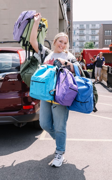 A member of the SAB carries backpacks for survivors of human trafficking.